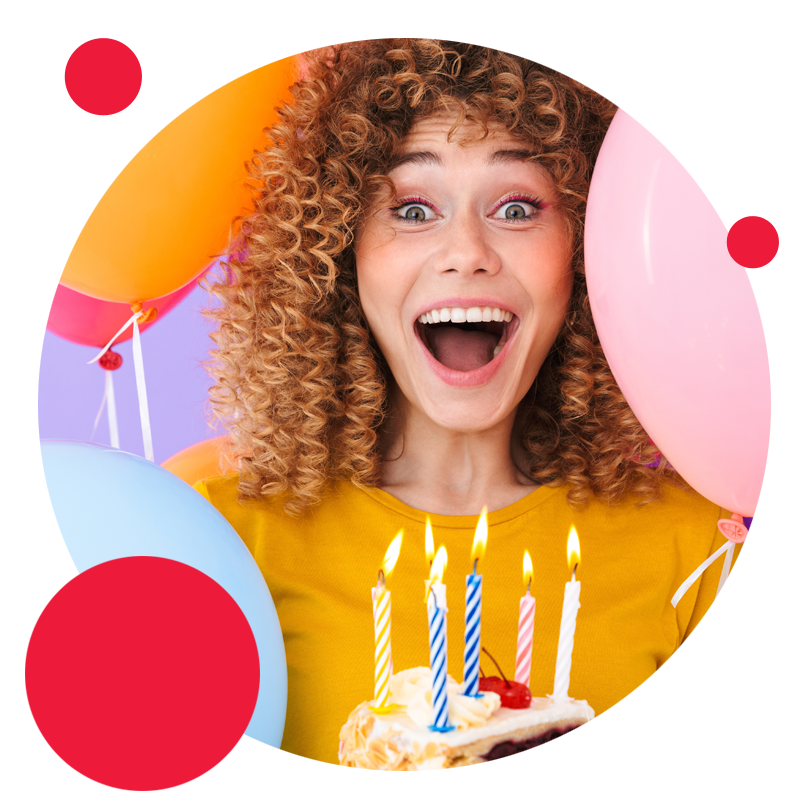 Uśmiecnięta kobieta z balonami wręcza tort